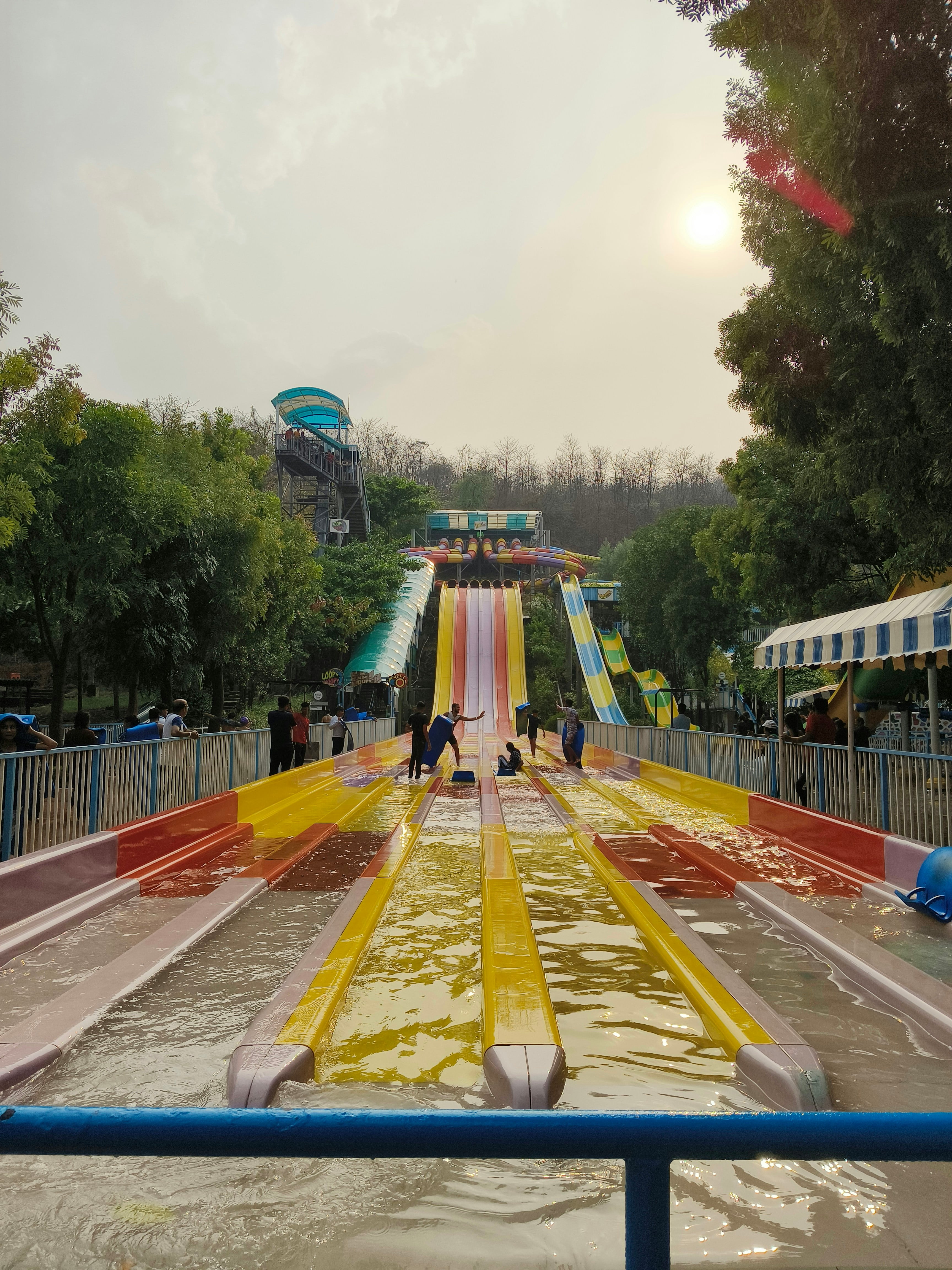 Tobogã de água colorido em parque aquático com crianças se divertindo